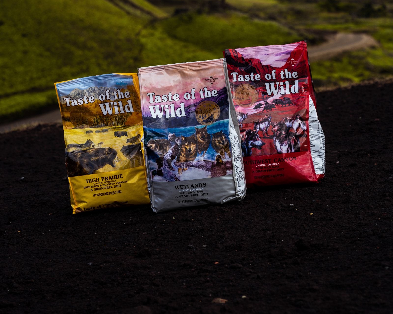 Þrír pokar af Taste of the Wild standa í íslensku fjallalandslagi.